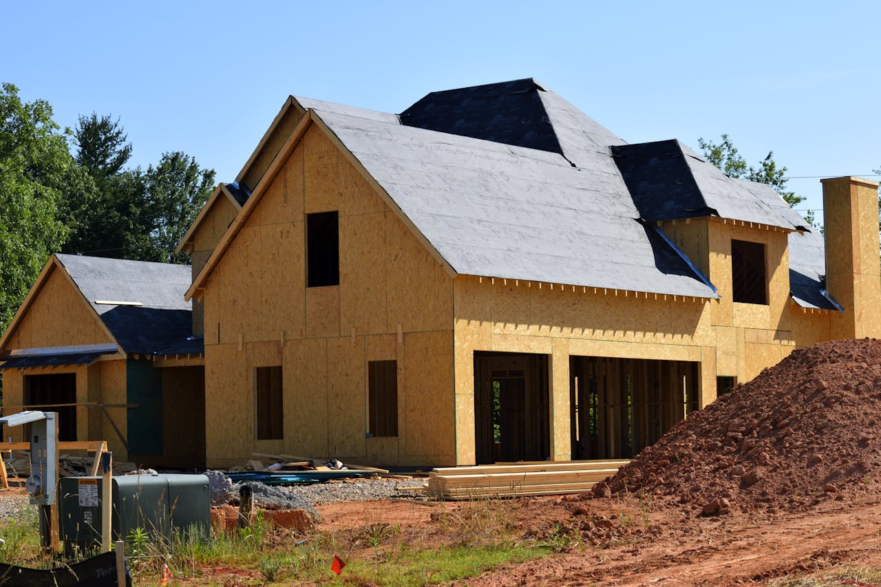 about-02 A partially built wooden house under construction, showcasing its progress and design in daylight.